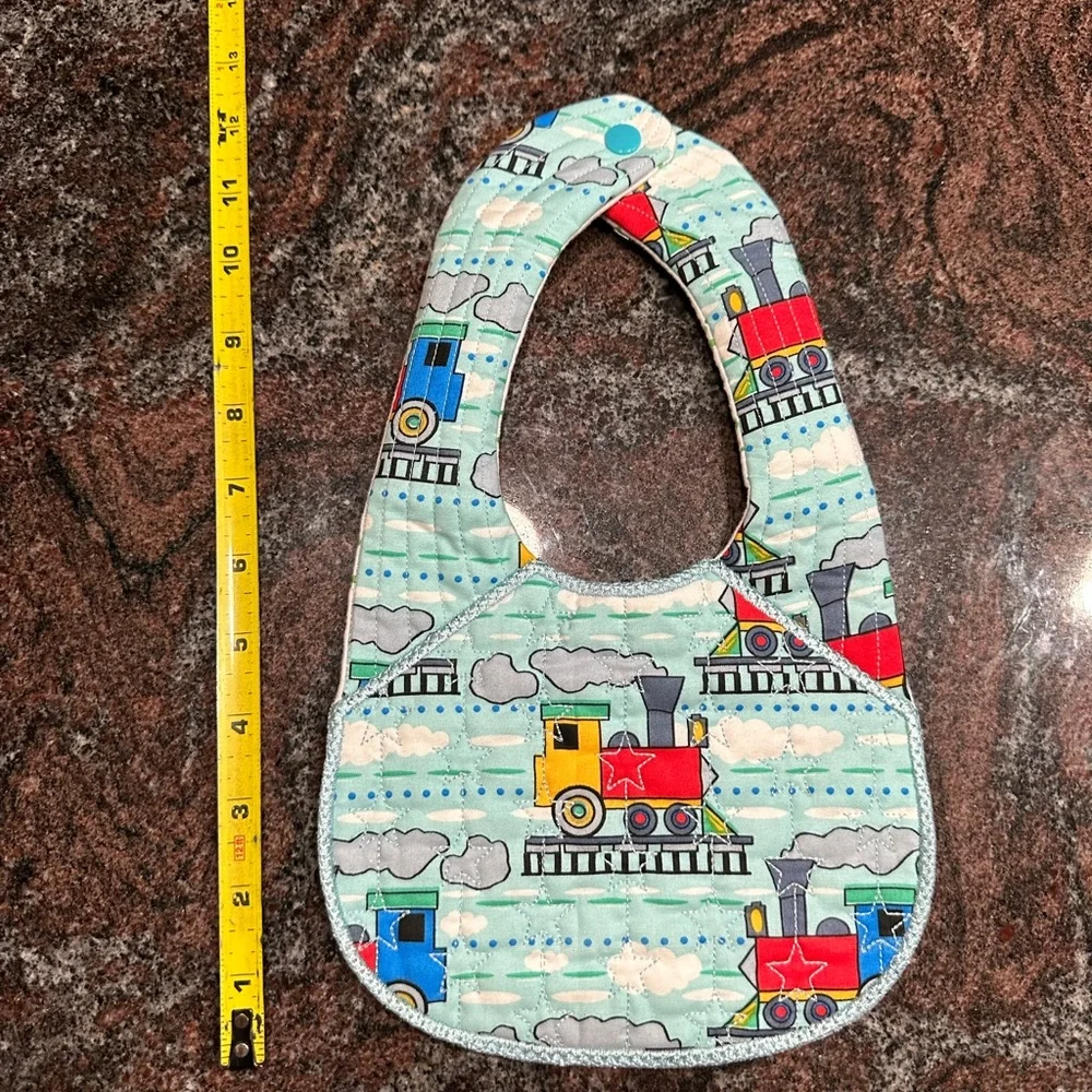 Handmade reversible quilted baby bib in train print